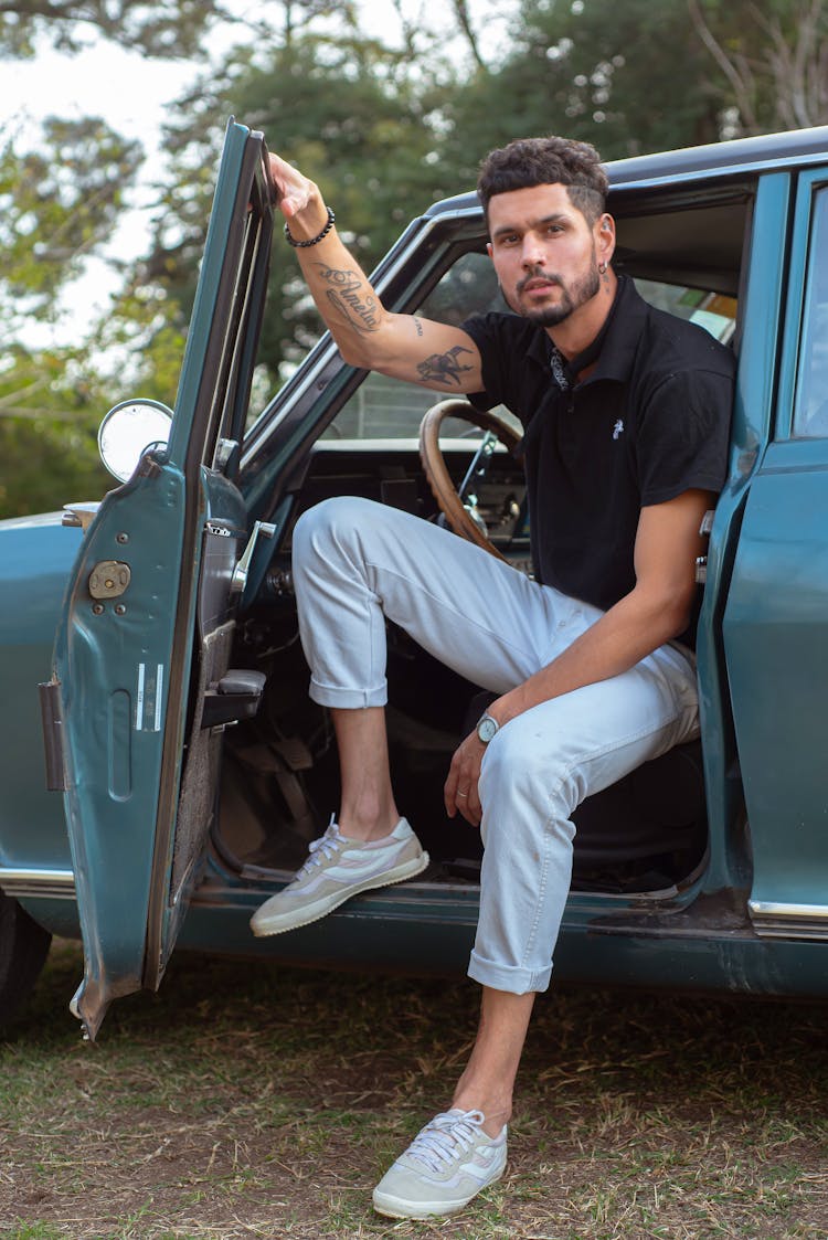 Man Sitting In Vintage Car Door