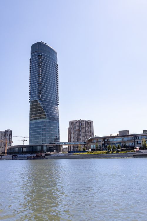 Free A modern skyscraper along the Danube River under a clear blue sky in Belgrade, Serbia. Stock Photo