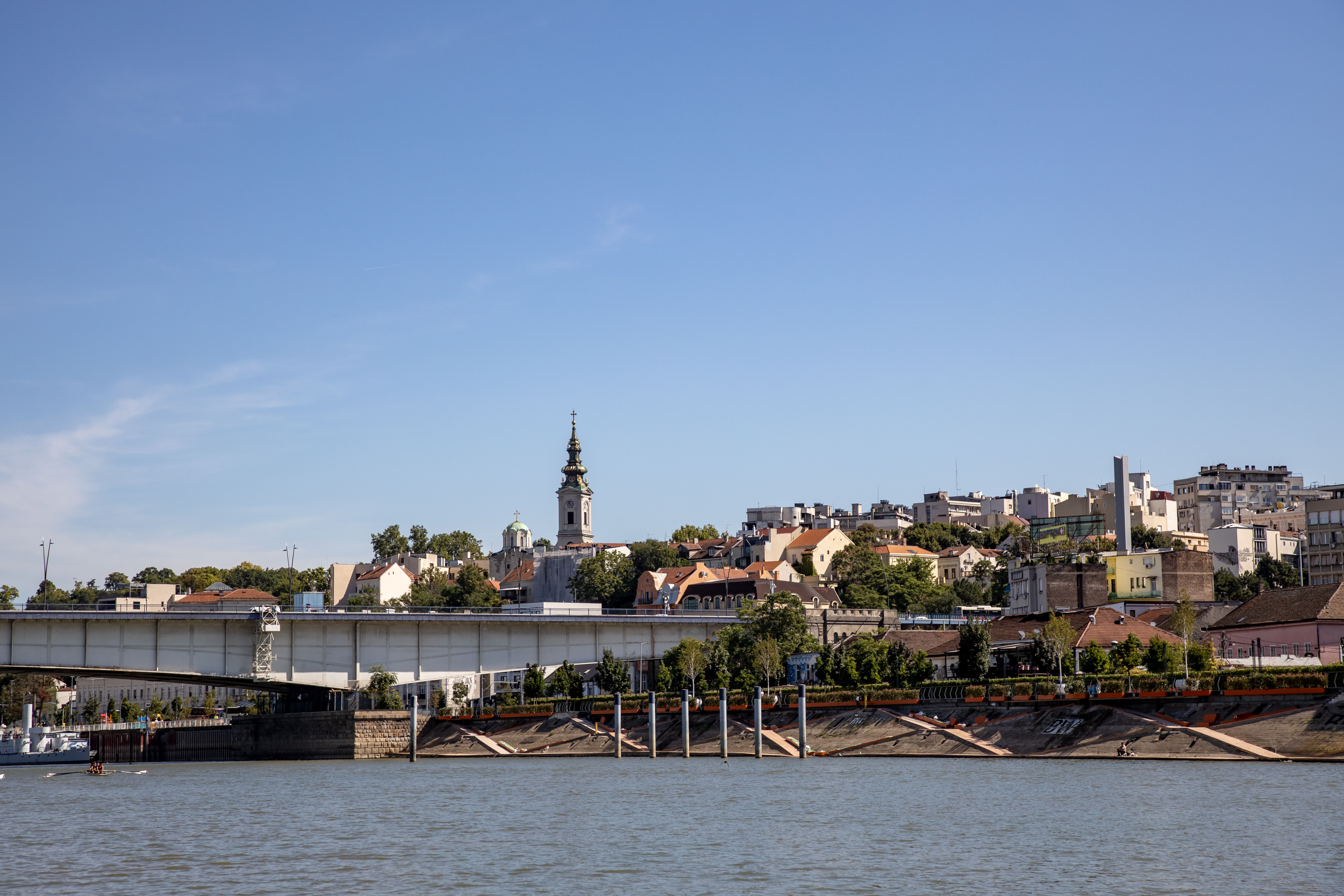 Panoramic view of Belgrade with a bridge, cityscape, and St. Michael's Cathedral.