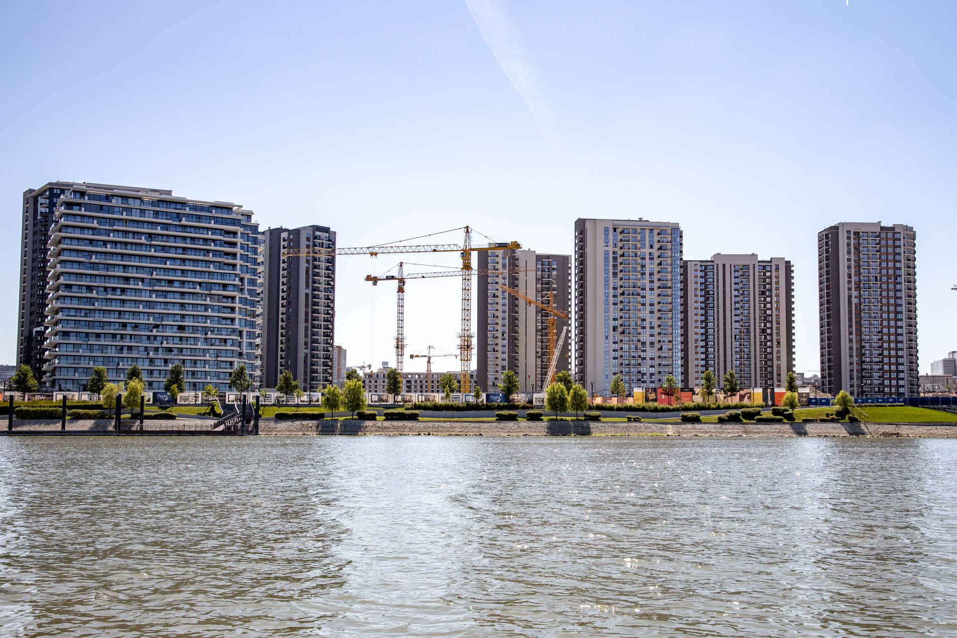 Modern buildings and cranes by the river in Belgrade, Serbia showcase urban development.
