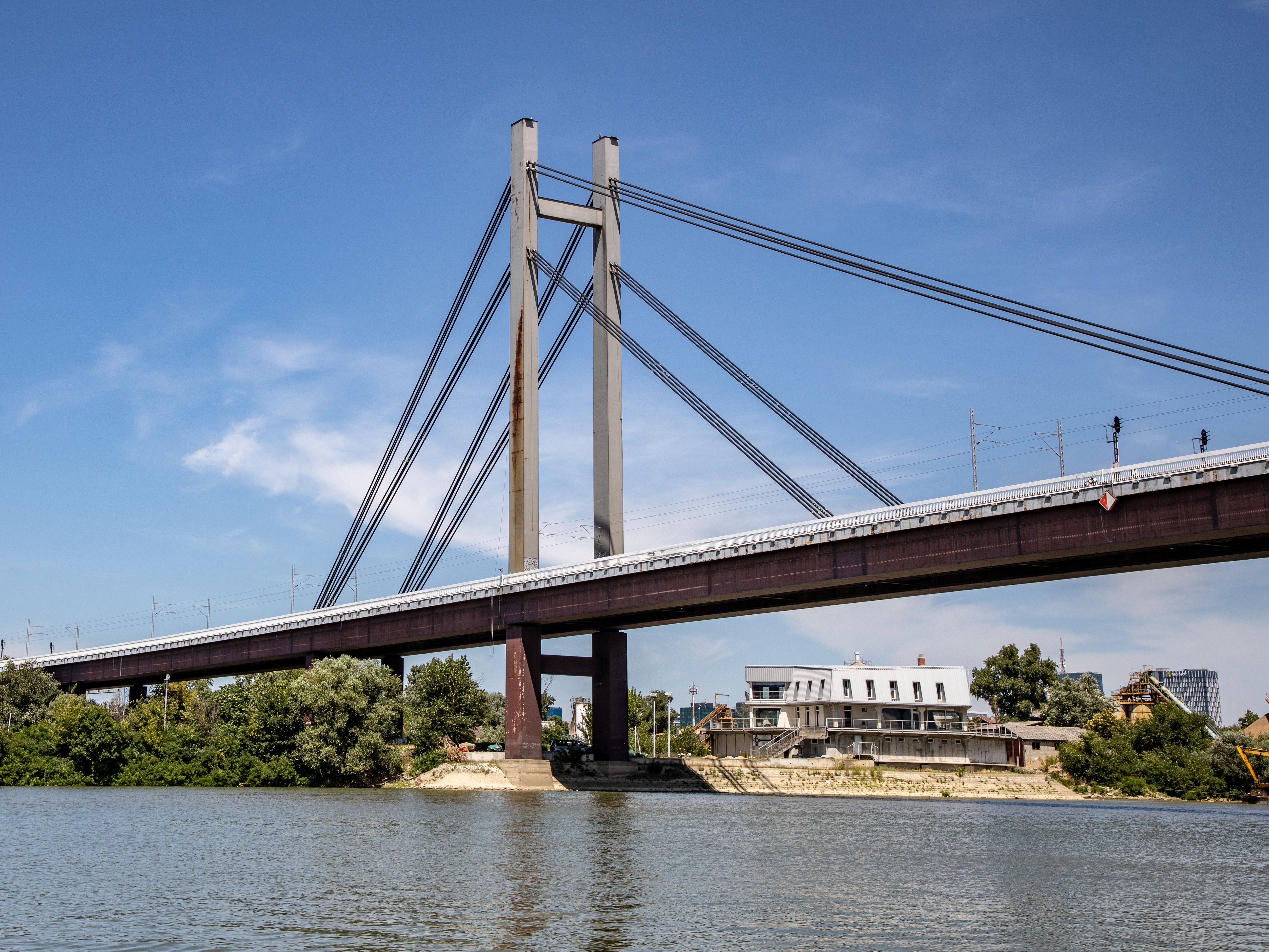 Capture of a modern railway bridge crossing the river in Belgrade under a clear blue sky.