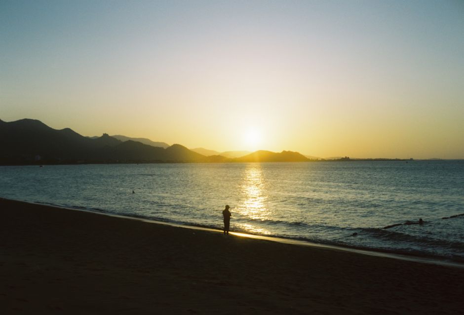 Peaceful beach scene with a silhouette at sunset, capturing the beauty of nature and tranquility.