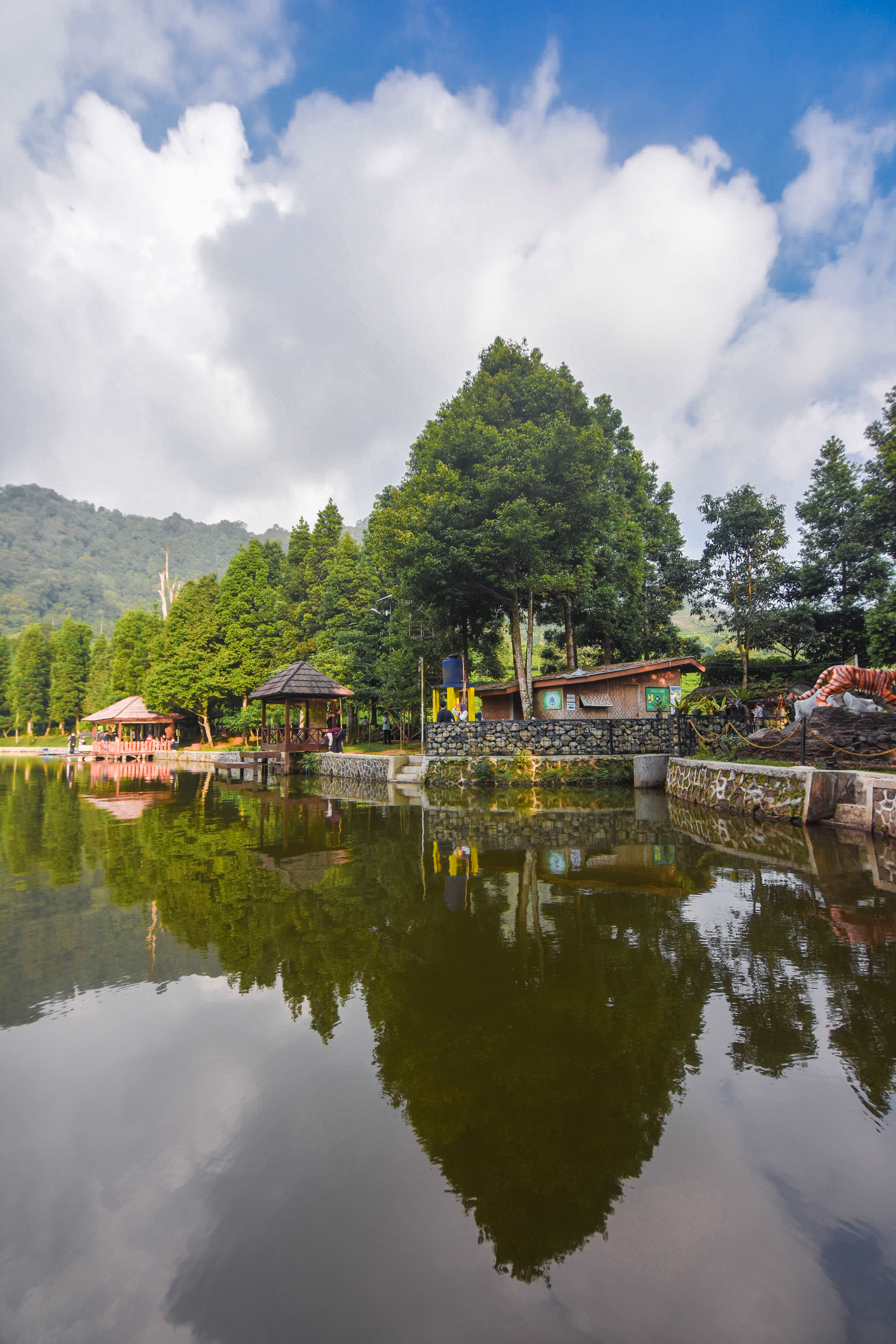 A serene lakeside view with trees and reflections under a vibrant sky.