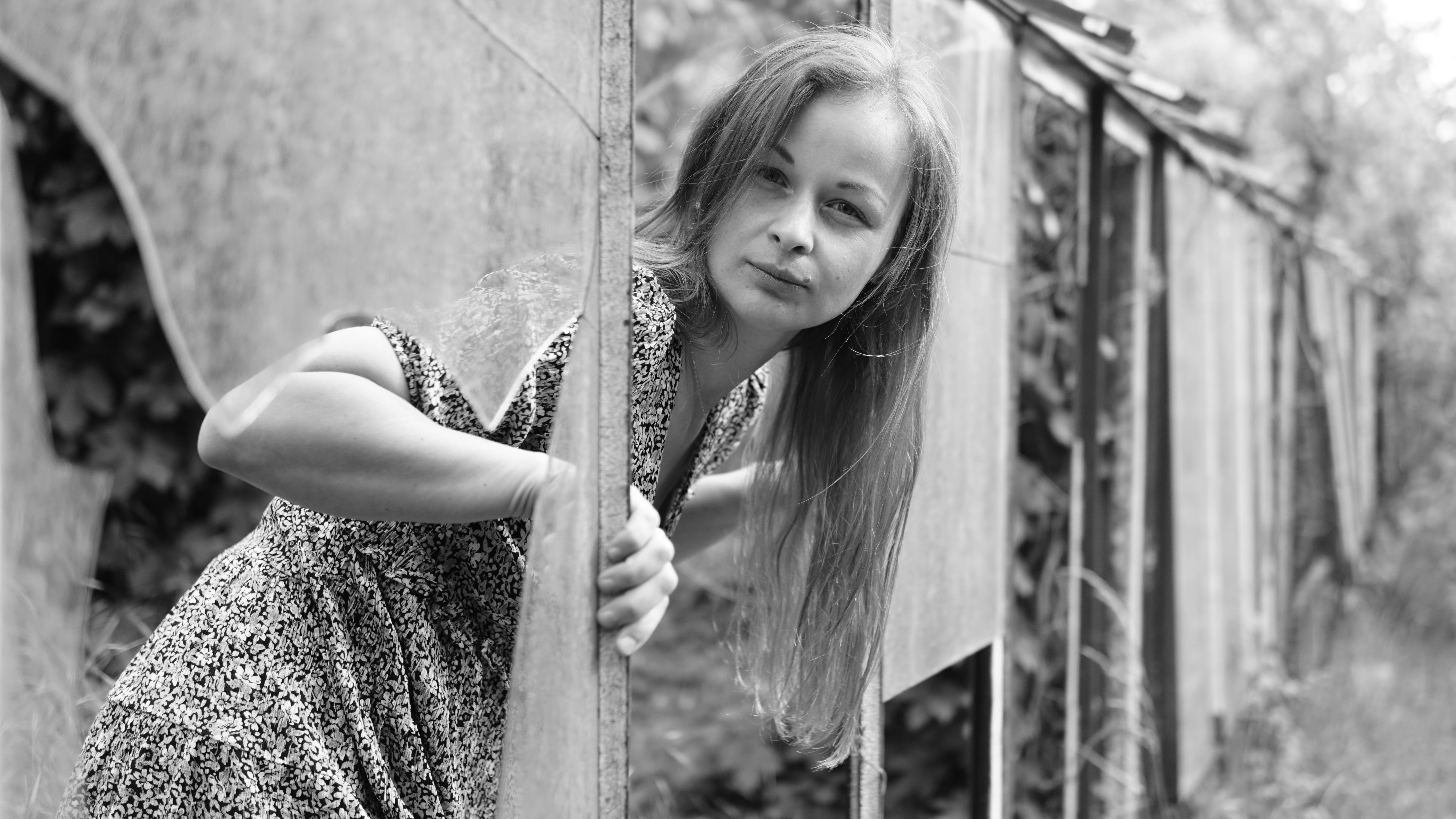 A black and white portrait of a woman outdoors, showcasing a serene expression.
