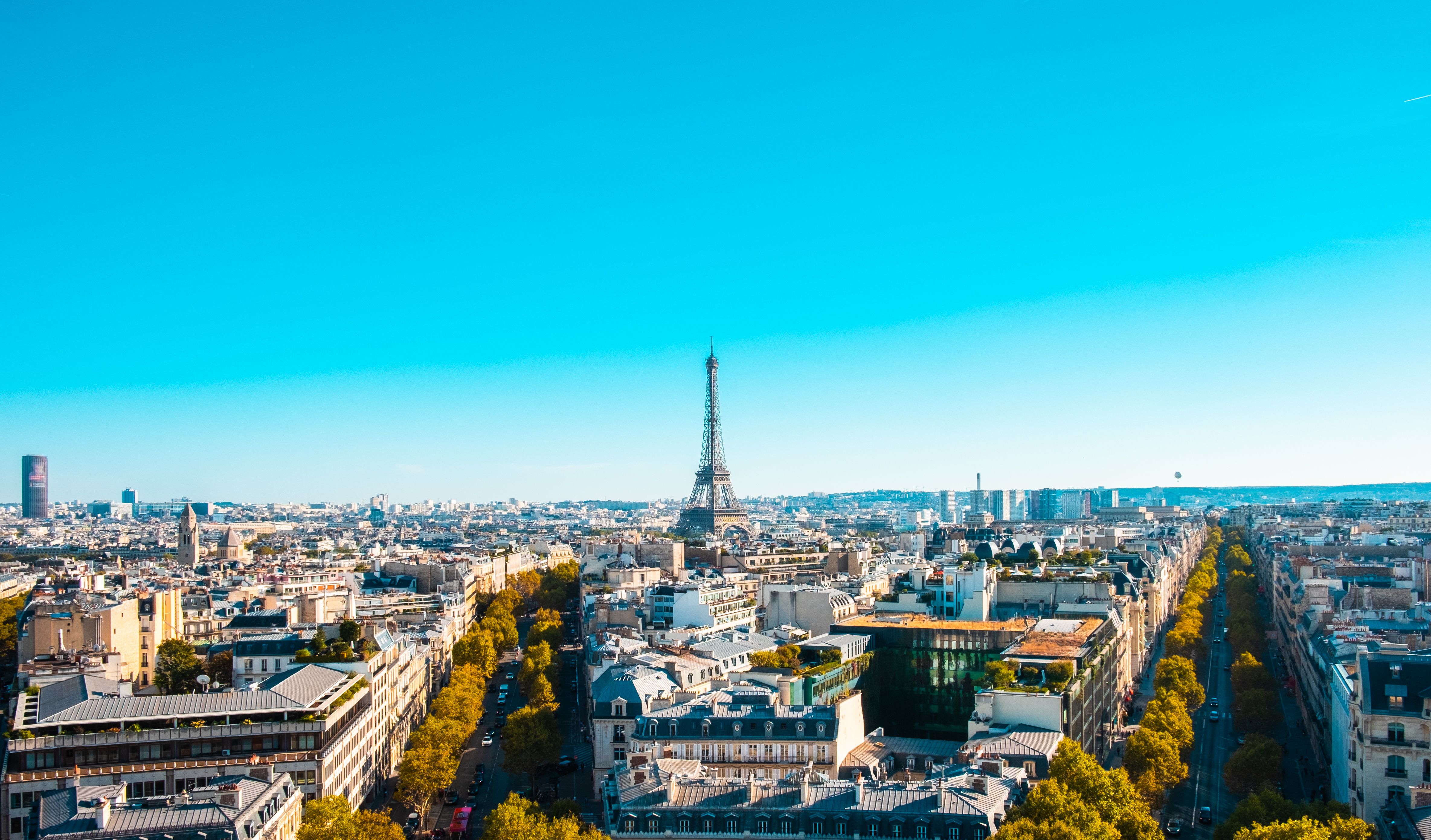 Stunning aerial view of Paris cityscape featuring the iconic Eiffel Tower on a clear day.