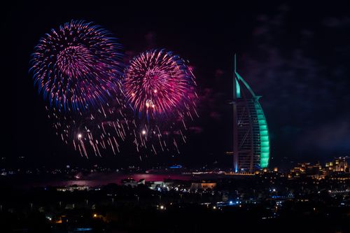 Free Vibrant fireworks illuminate the night sky over Dubai's iconic Burj Al Arab. Stock Photo