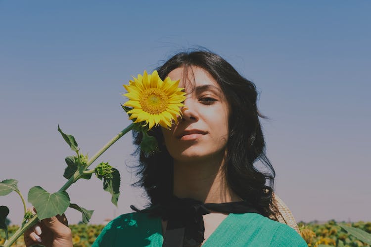 Woman Covering Eye With Sunflower