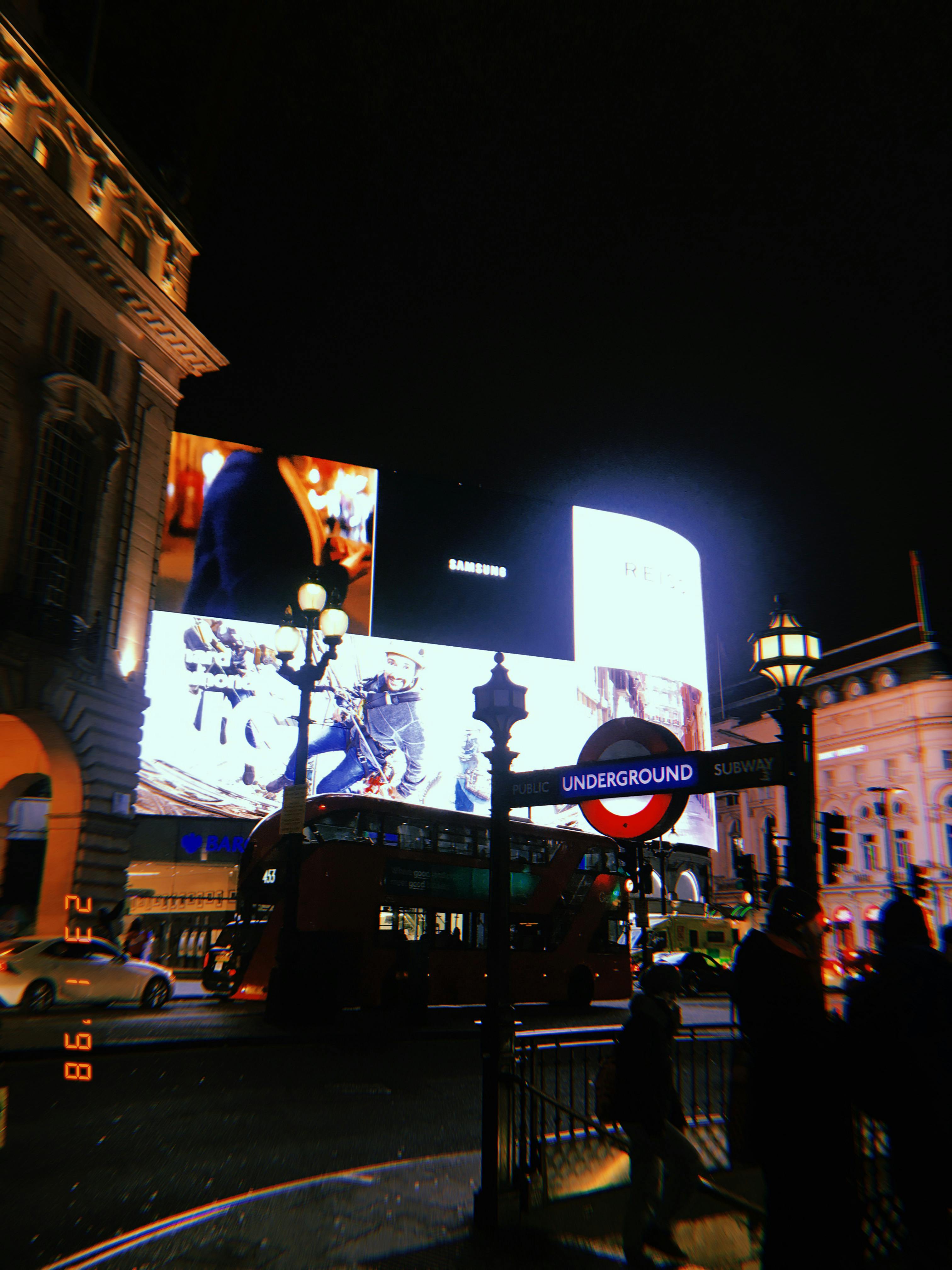 Captivating view of Piccadilly Circus at night with illuminated billboards and iconic red double-decker buses.