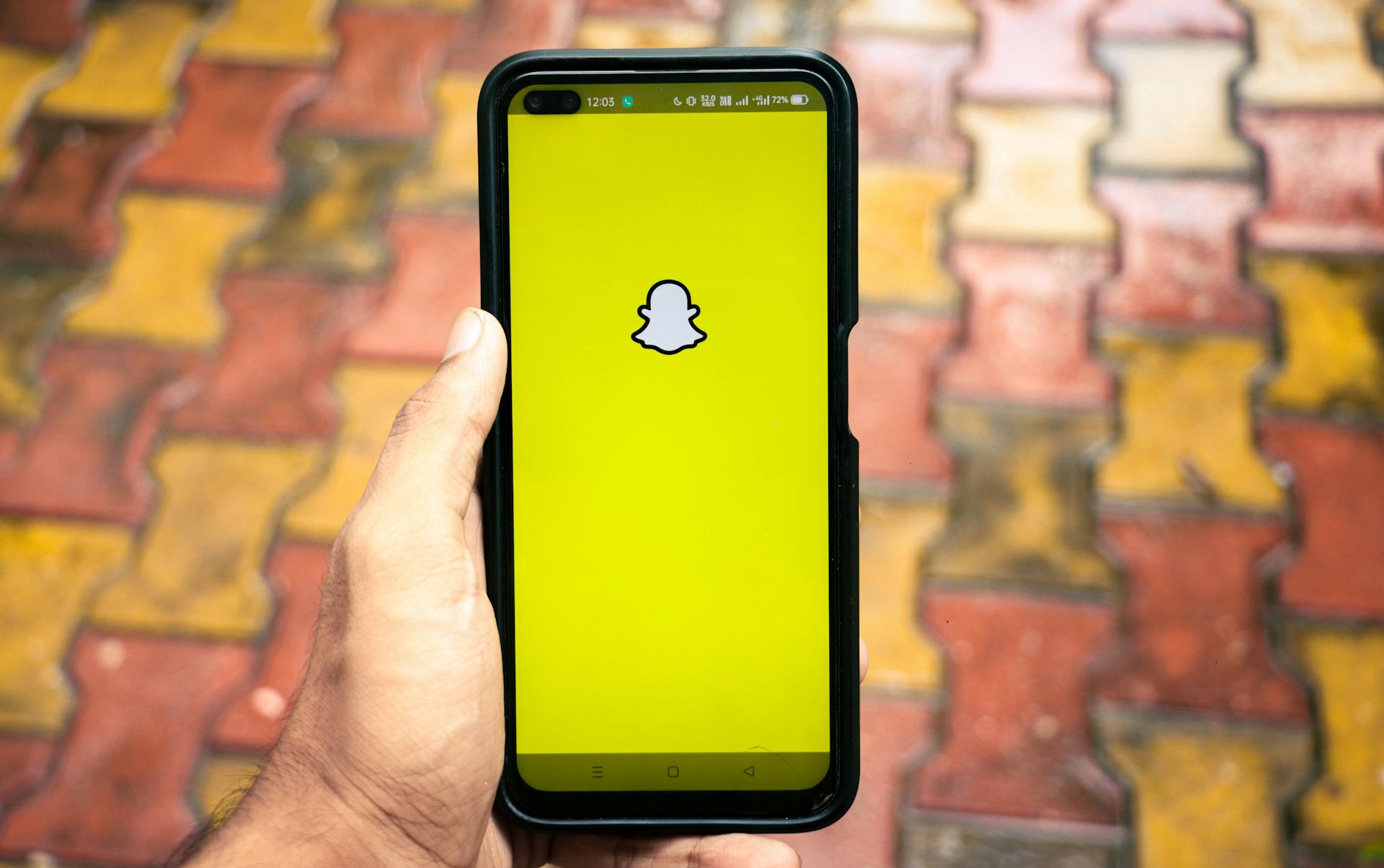 Man holding a iPhone X with social network service Snapchat on the screen. iPhone X was created and developed by the Apple inc. Snapchat application on iPhone X