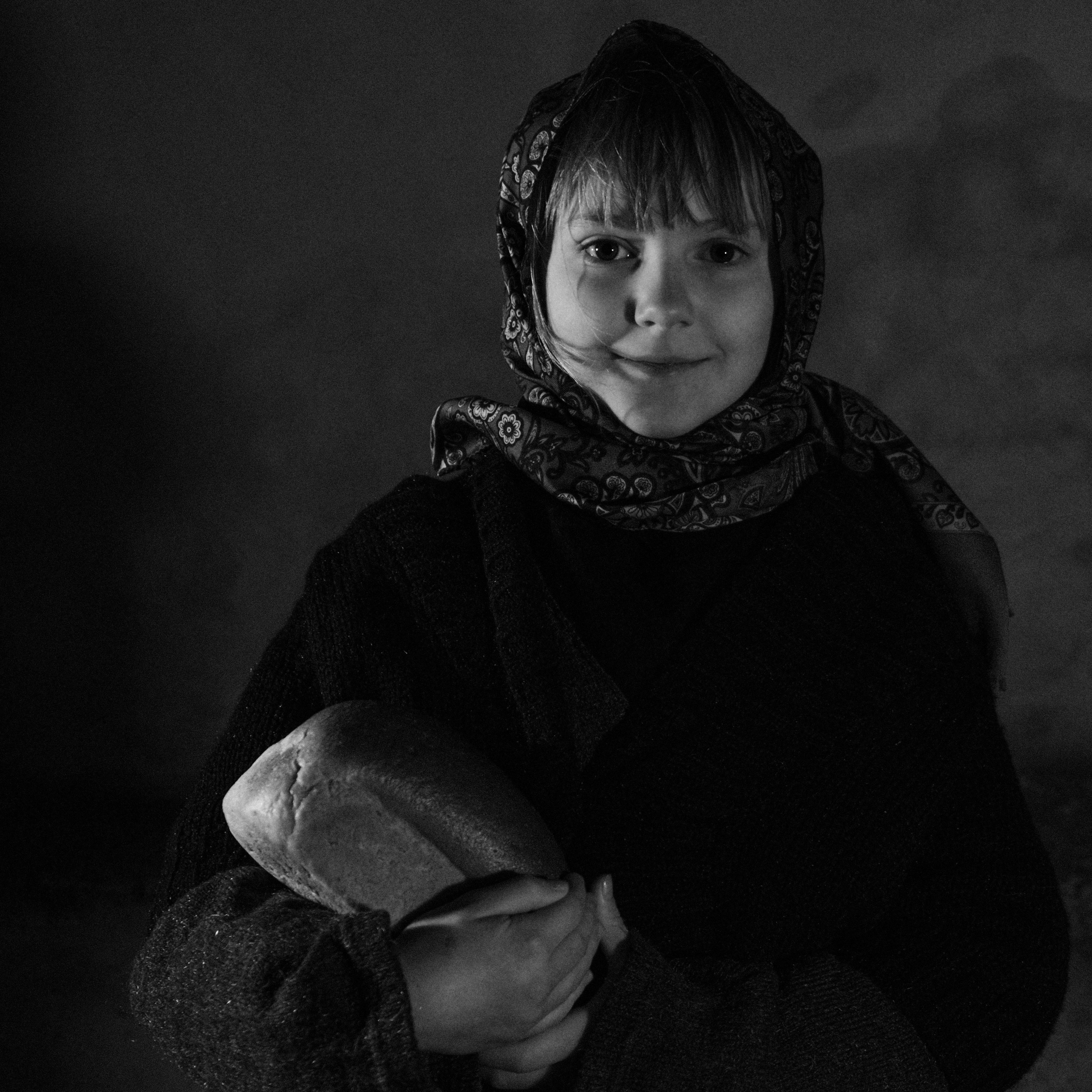 Smiling Girl Holding a Loaf of Bread 
