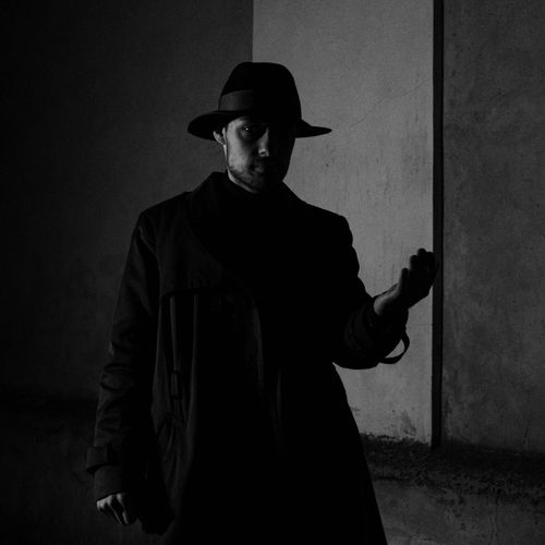 Free Dark, mysterious portrait of a man in a hat and coat, exuding intrigue. Stock Photo