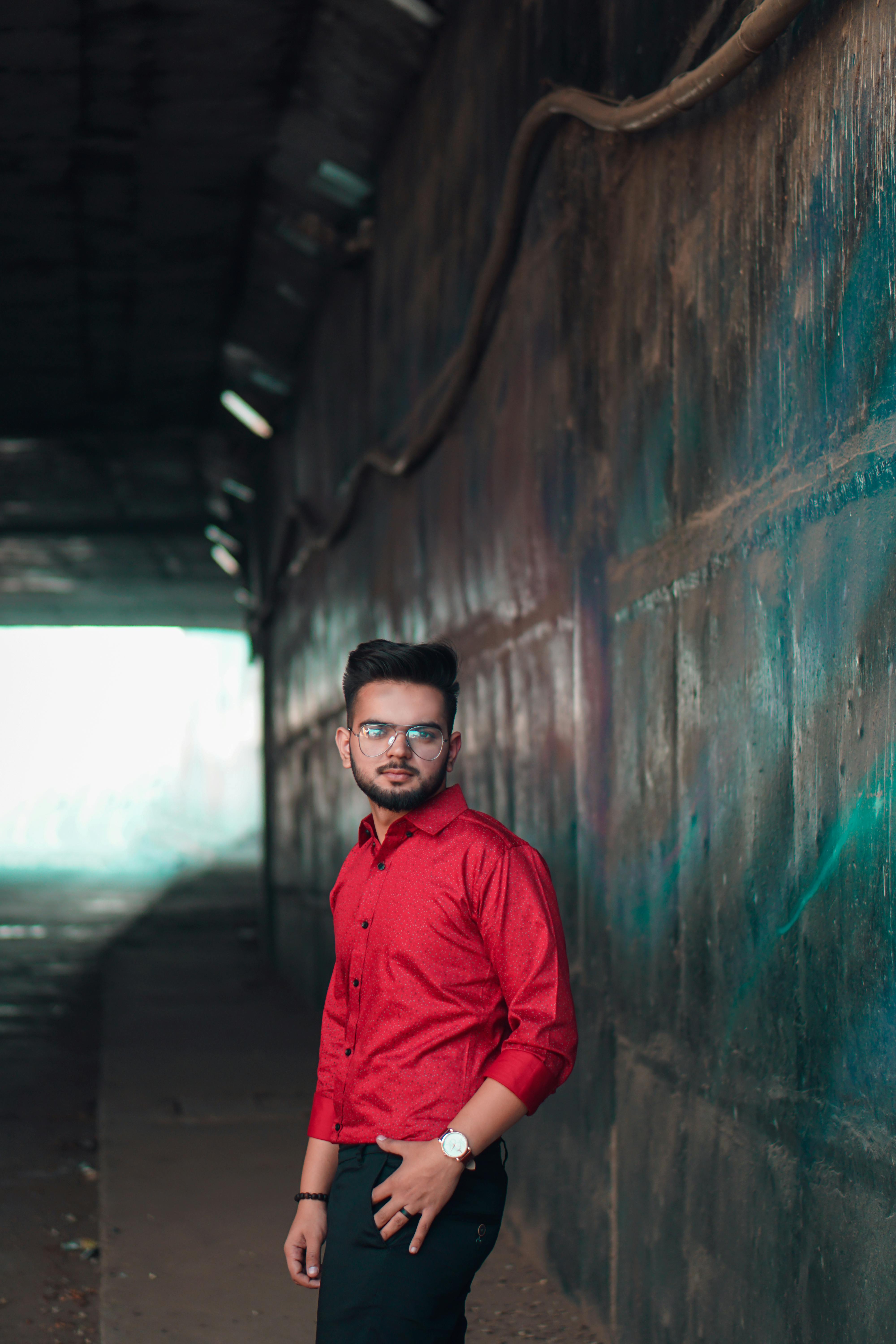 一位时尚男子穿着红色衬衫，在城市隧道中摆姿势的肖像