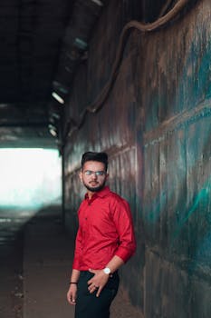 一位时尚男子穿着红色衬衫，在城市隧道中摆姿势的肖像