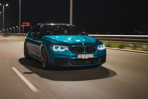 Man Driving a Blue BMW M5 on a Street 