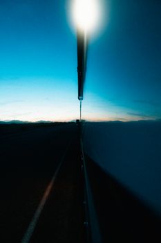 Captivating twilight view of Mojave Desert road with reflections and silhouettes.