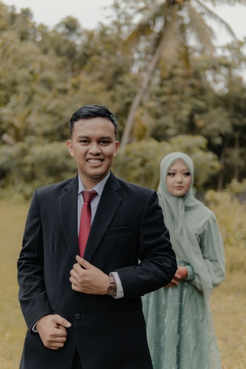 Free A happy couple in elegant attire during an outdoor wedding photoshoot in Pacitan, East Java, Indonesia. Stock Photo