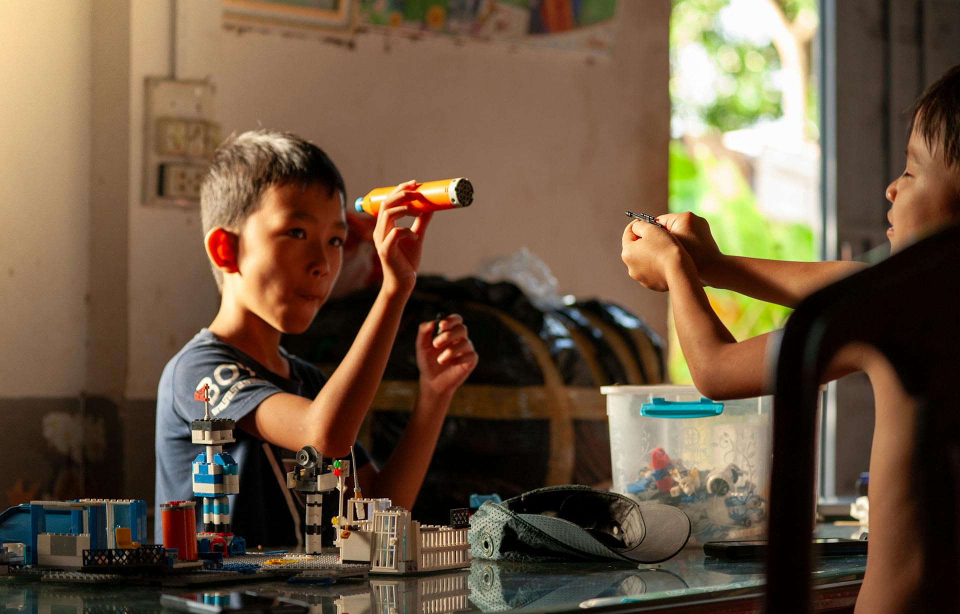Two boys enjoying creative play with plastic building blocks indoors.