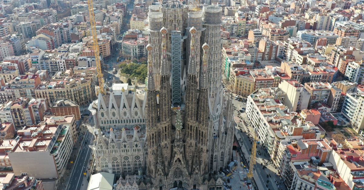 Stunning aerial shot of the iconic Sagrada Familia cathedral in Barcelona, showcasing its intricate architecture and surrounding urban landscape.