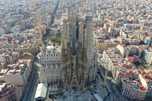 Stunning aerial shot of the iconic Sagrada Familia cathedral in Barcelona, showcasing its intricate architecture and surrounding urban landscape.