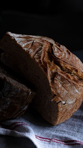 Cut sourdough loaf on linen — photo by Merve on Pexels