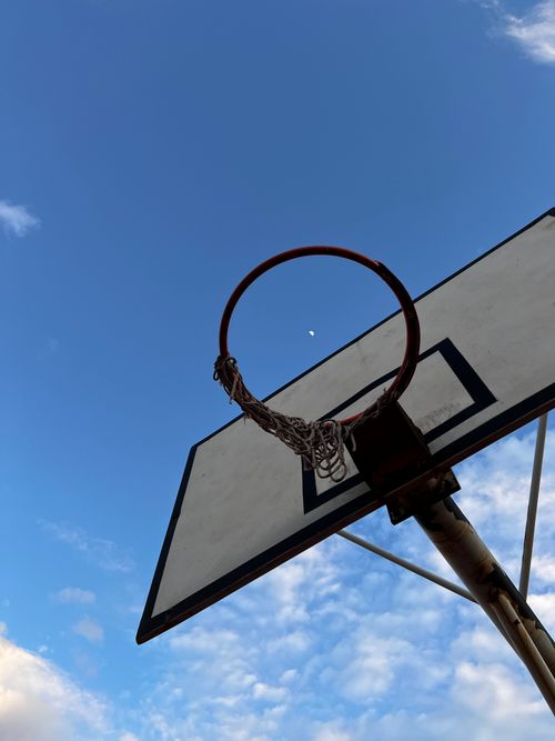 Free Basketball hoop silhouetted against a clear sky with the moon visible in Antalya, Türkiye. Stock Photo