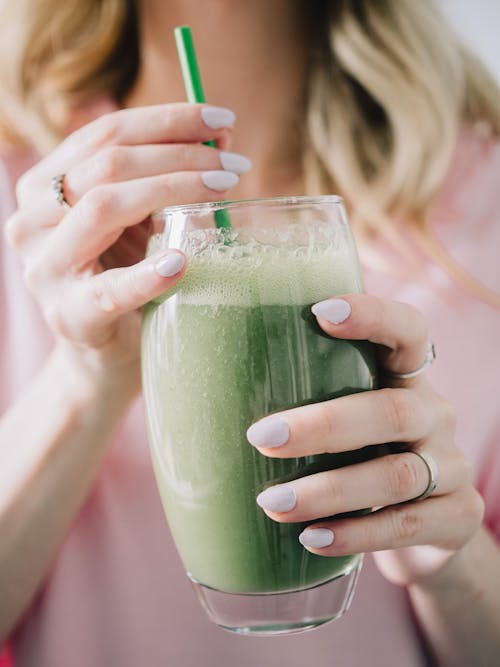 Free Hands Holding Glass of Green Smoothie Stock Photo