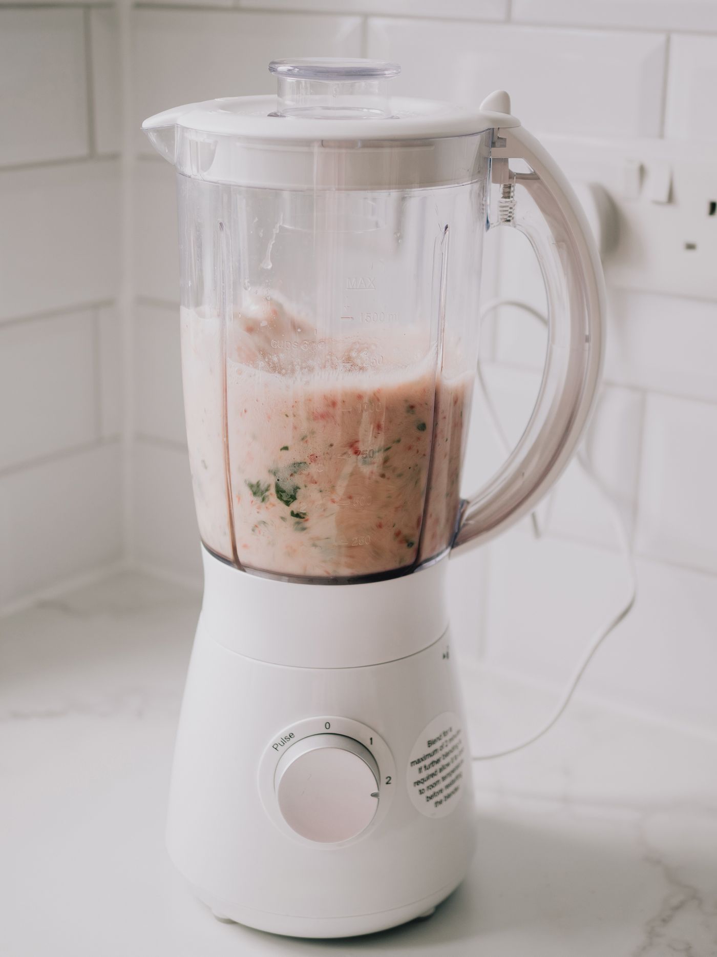 Blender with fresh ingredients prepared on a kitchen countertop