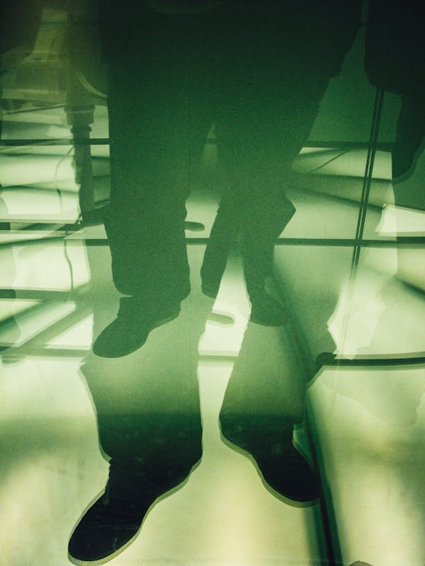 Crop faceless man legs standing on white floor
