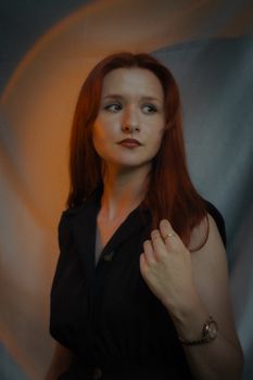 Portrait of a young redheaded woman in a black romper, emphasizing elegance and fashion.