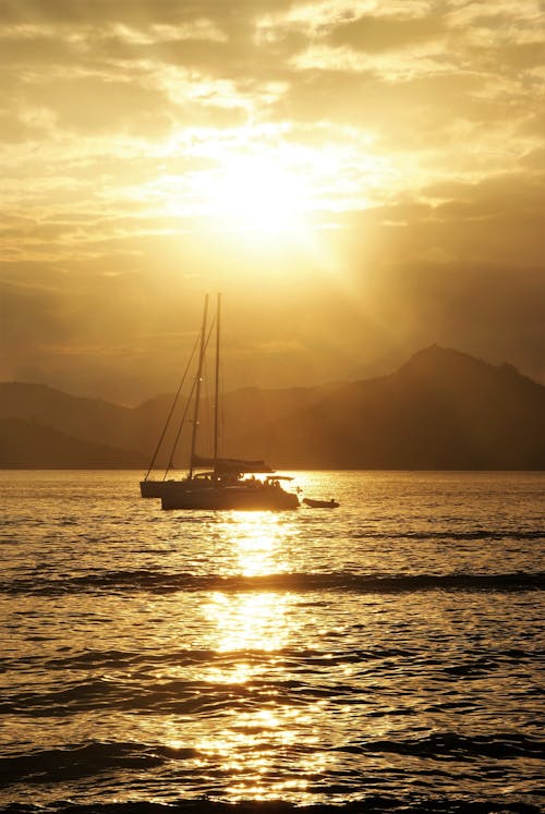 Immagine gratuita di acqua, barca a vela, cielo giallo