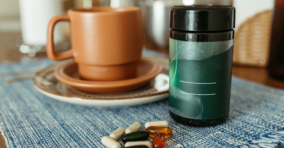 A variety of capsules near a ceramic mug and container on a table. A variety of capsules near a ceramic mug and container on a table.