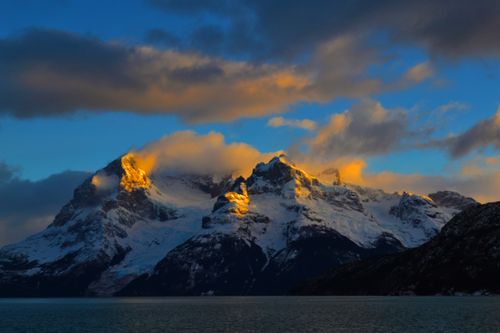 Free Snowcapped mountain range with golden sunrise illumination, capturing natural splendor. Stock Photo