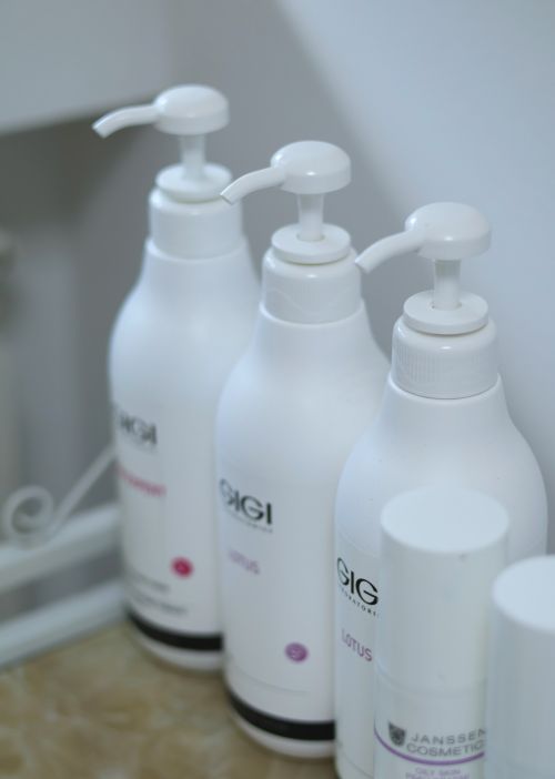 Free Close-up of white skincare product bottles arranged neatly on a shelf in a beauty salon. Stock Photo