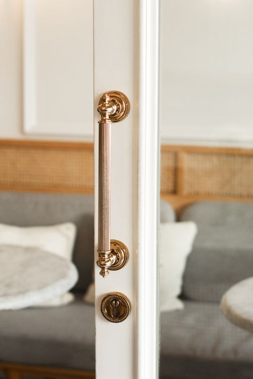 Polished brass pull on a panelled interior door — photo by Esra Erdem on Pexels