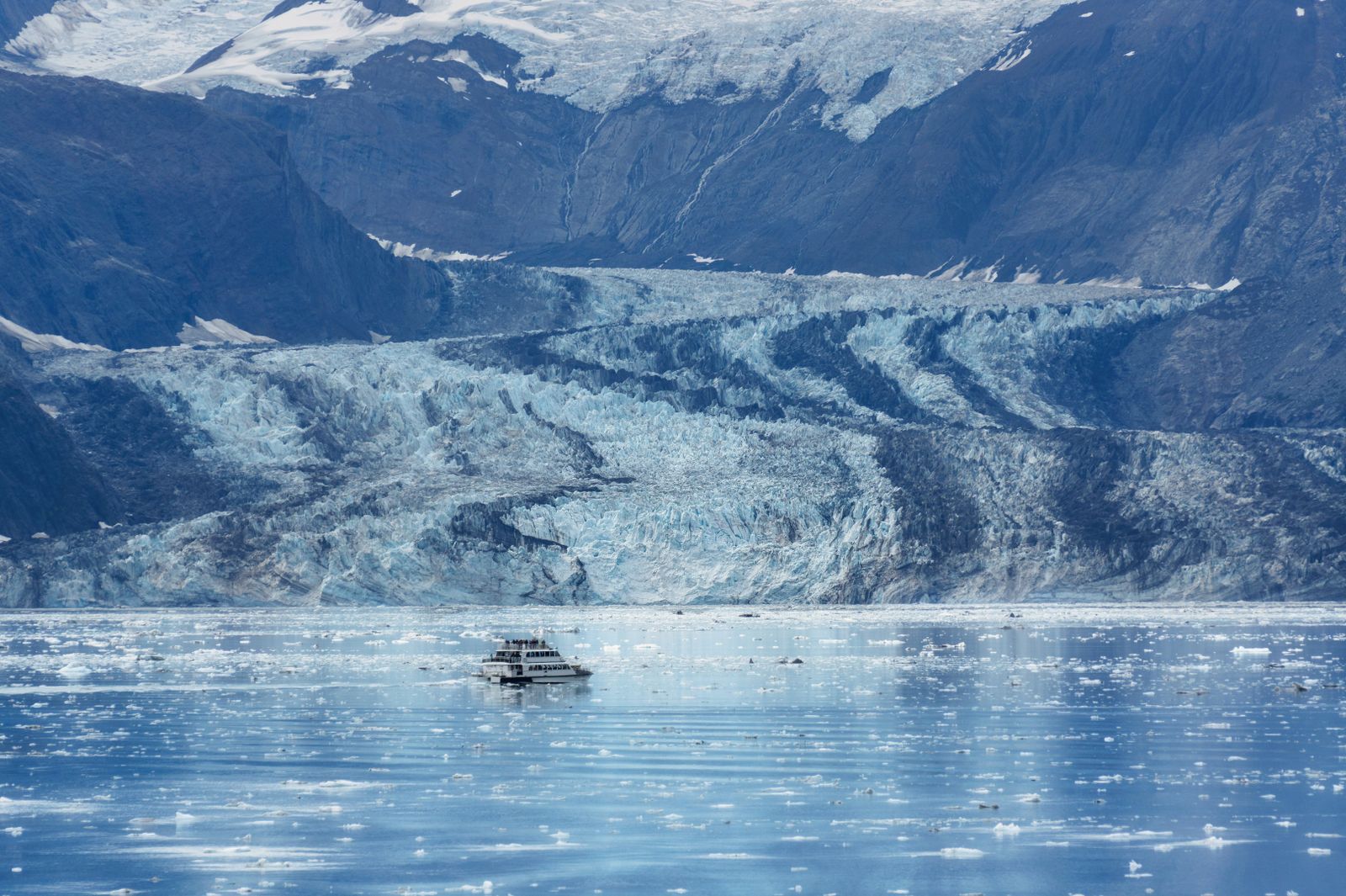 Ship sailing an icy glacier fjord