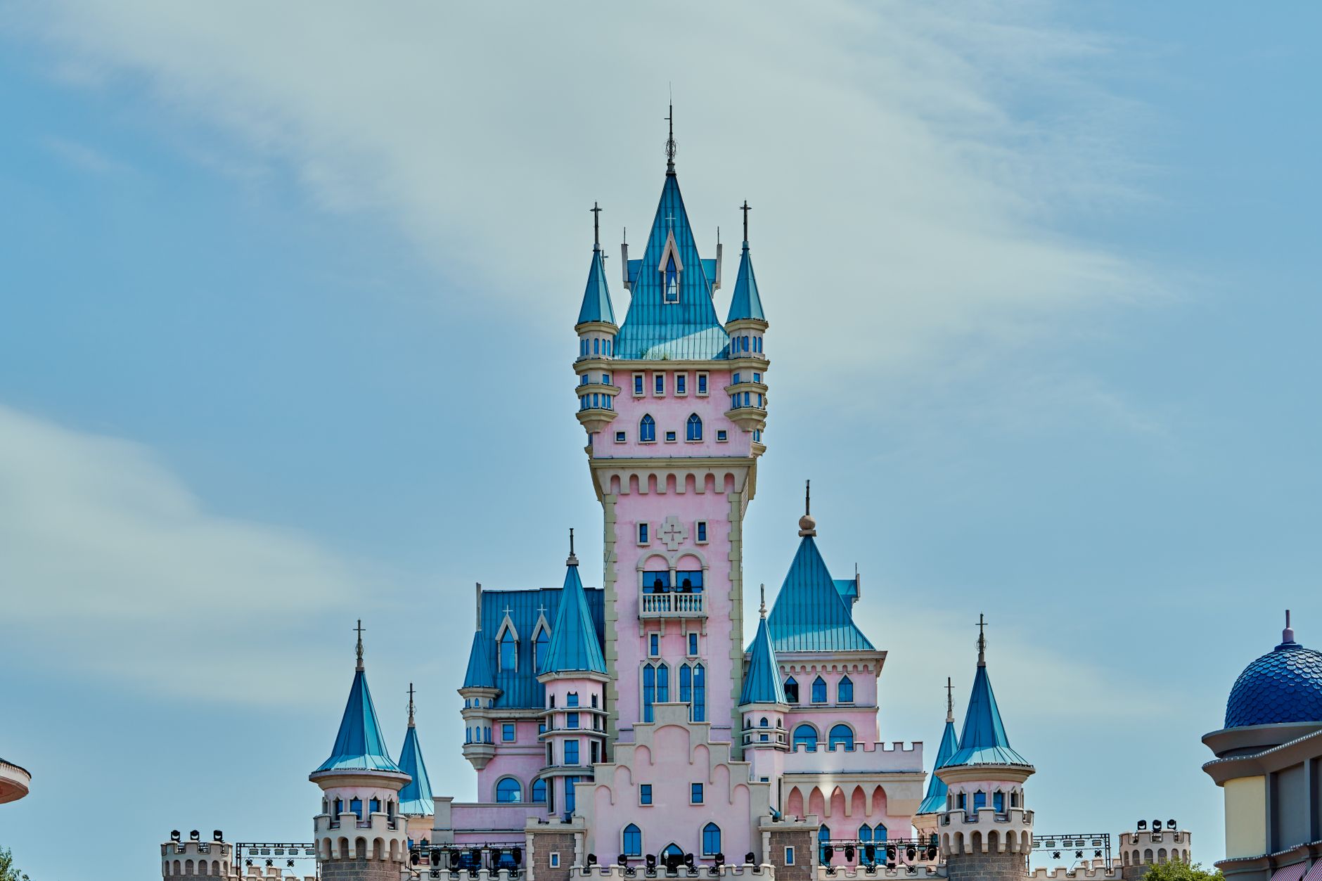 A stunning pink and blue castle with turrets under a clear sky, evoking a fairytale ambiance. — free online jigsaw puzzle on JigsawPuzzlesFreeOnline.org