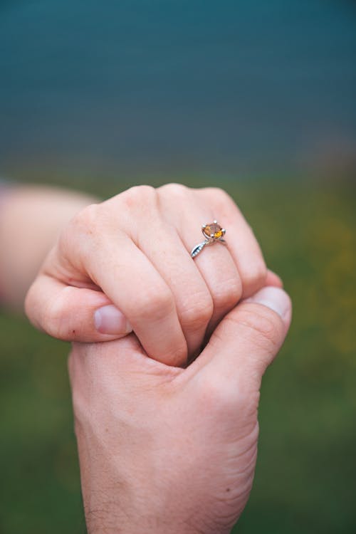 Man Holding Womans Hand with Engagement Ring