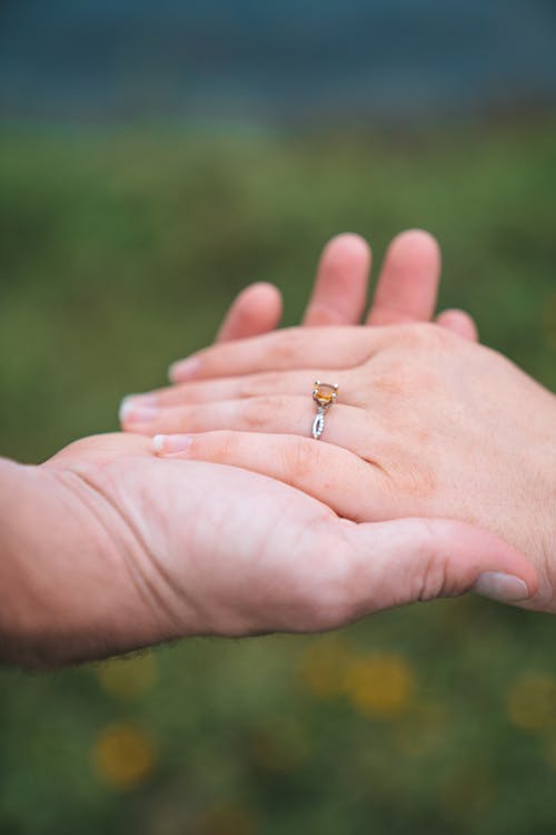 Womans Hand with Engagement Ring in Hand of Man