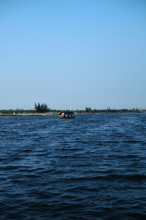 A Boat on a Body of Water under Clear Blue Sky 
