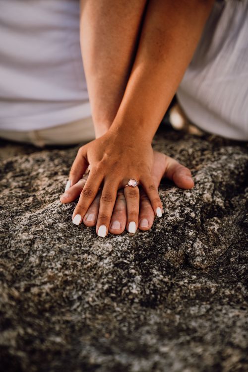 Free Close-up of a couple's hands with an engagement ring on a rock, symbolizing love. Stock Photo