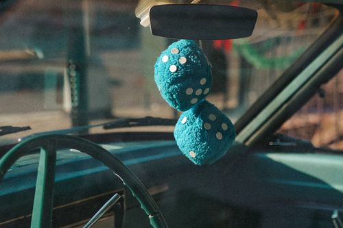 Free Close-up of blue fuzzy dice hanging from the rearview mirror of a classic car in New York. Stock Photo
