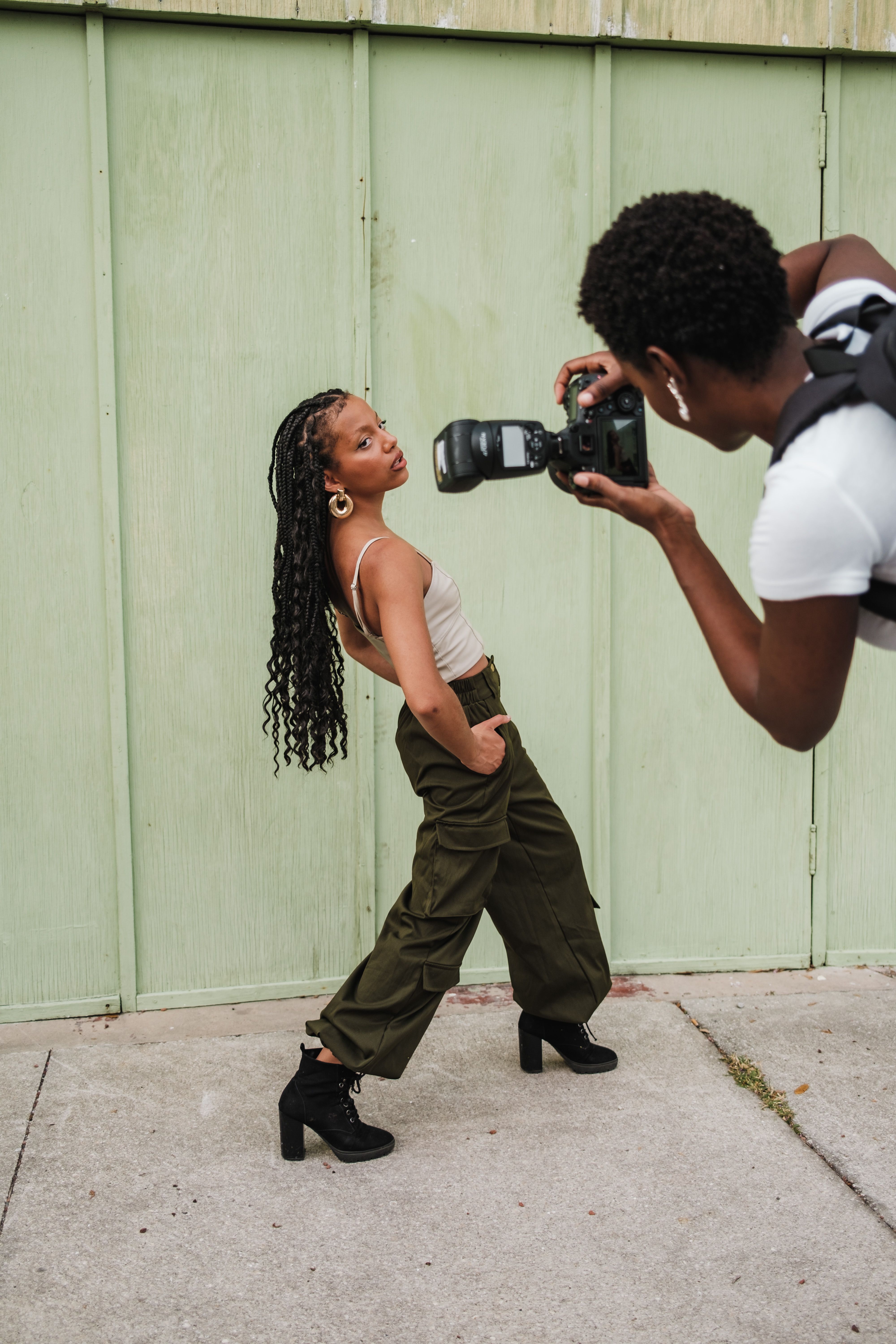 Dynamic urban photoshoot featuring a model posing for a photographer outdoors.