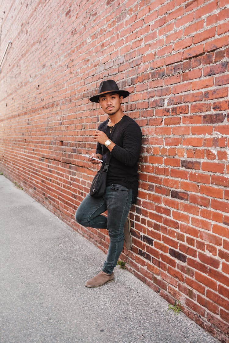 Man In Hat Posing By Wall