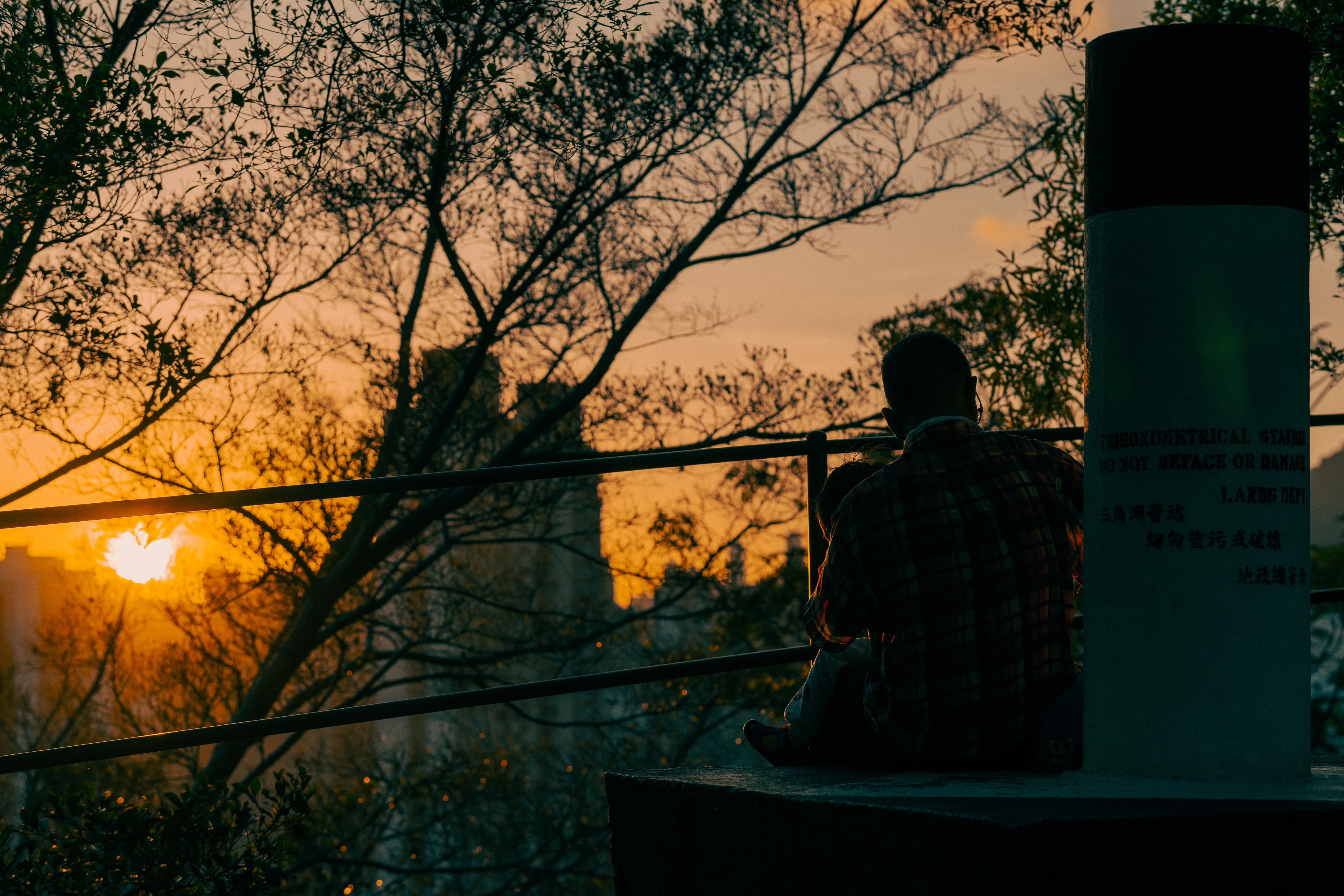 A person sitting on a porch drinking tea, looking at a sunset, no phone in sight
