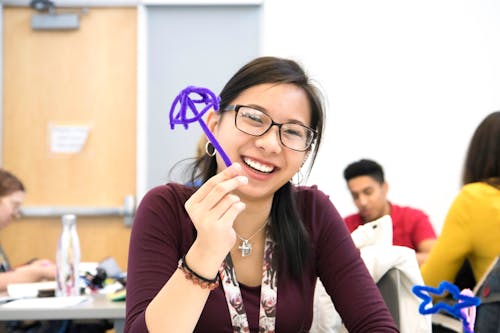 Smiling Woman in Eyeglasses Holding Toy