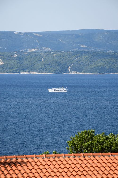 Free Serene view of a boat sailing in the Adriatic Sea with coastal hills in the background, Croatia. Stock Photo