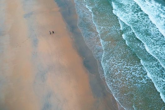 A serene aerial view captures the vast beach and rolling waves at Kijal, Terengganu, Malaysia.