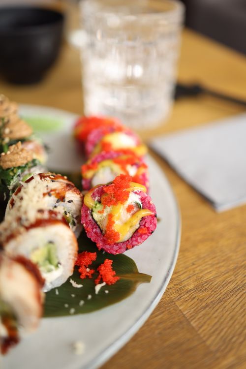 Free A vibrant plate of sushi rolls featuring bright ingredients and garnishes, ideal for culinary presentations. Stock Photo