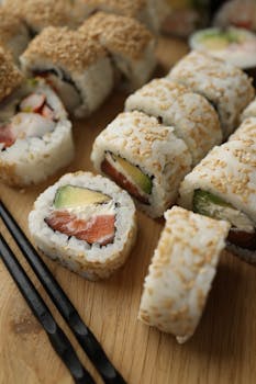 Fresh sushi rolls with seafood, avocado, and rice on a wooden board.