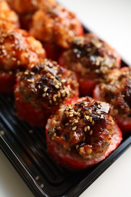 Free Delicious gourmet meatballs garnished with sesame seeds in a mouthwatering close-up shot. Stock Photo